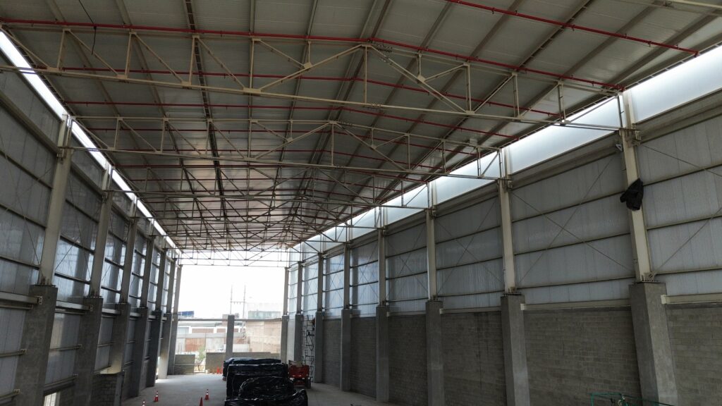 Interior de nave industrial con estructura metálica en Lima